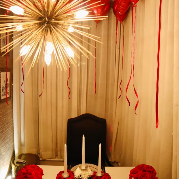 A room dressed with red hearts, roses and a starburst chandelier