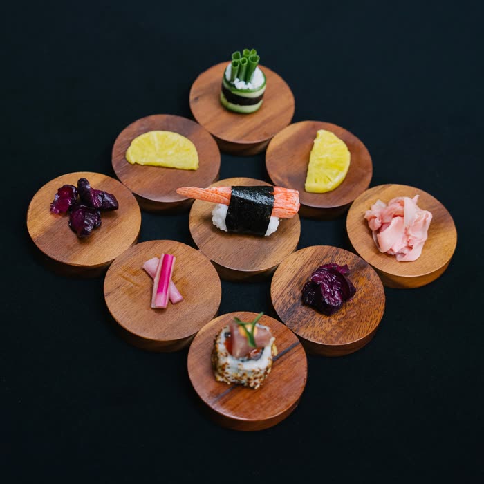 Nigiri served on individual turned-wood coasters