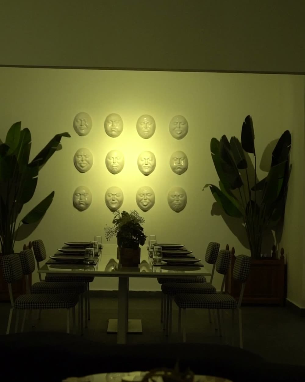Art Room with a wall of white sculpted faces above a long table