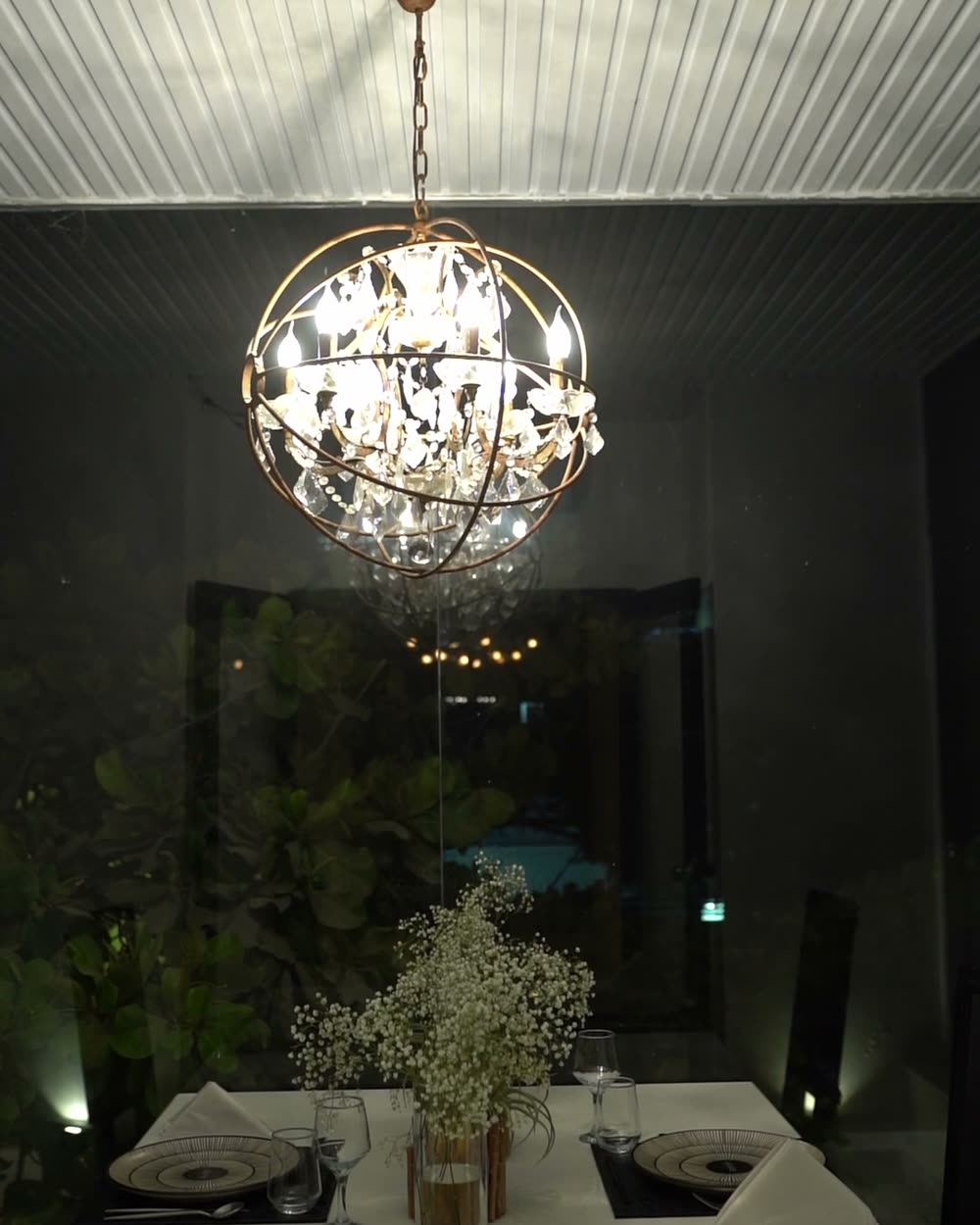 Balcony table for two beneath an orb chandelier