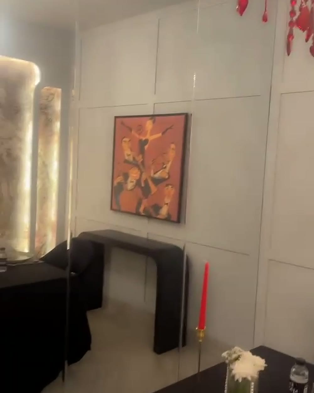 Red Room with a red crystal chandelier, backlit columns and a black table for two