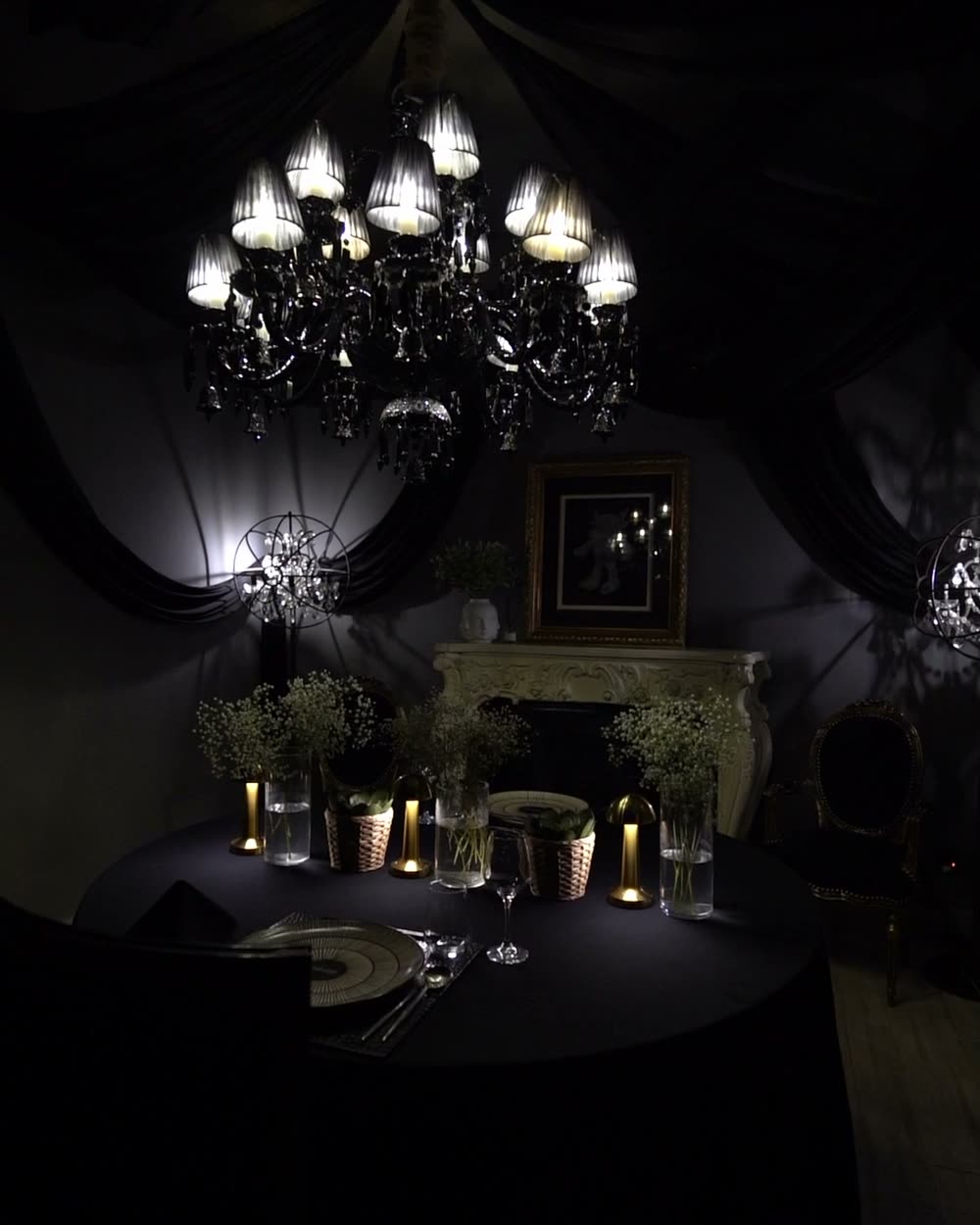 Shah Room with draped walls, candles and a black crystal chandelier